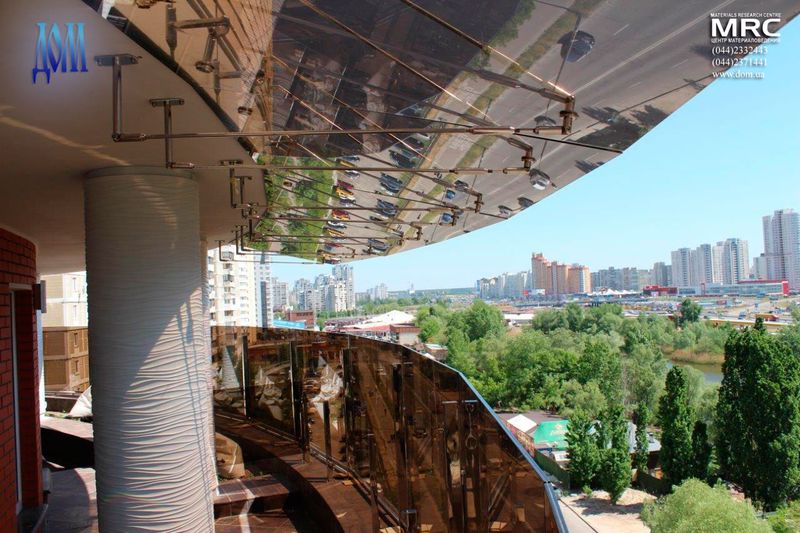 Козирки з металу і скла над терасою і скляним огородженням для захисту від вітру на великій висоті